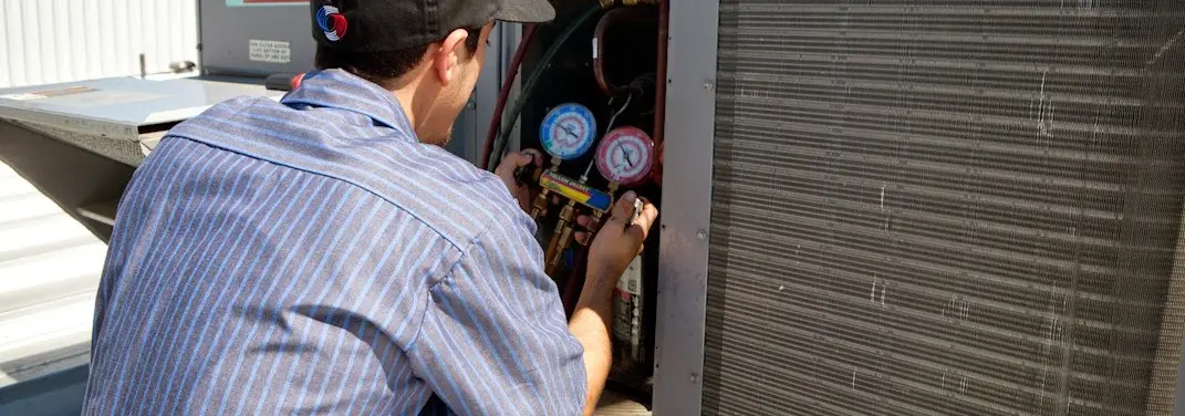 HVAC technician servicing a condenser unit in Zephyrhills